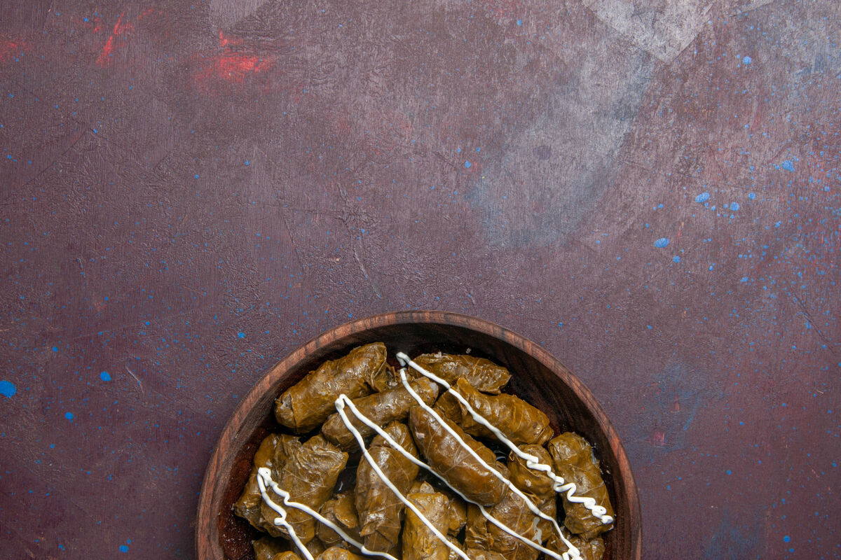 约束俯瞰美味的多尔玛东方菜与叶子和肉末在黑暗的背景热量晚餐肉食油菜里面管乐器叶内部