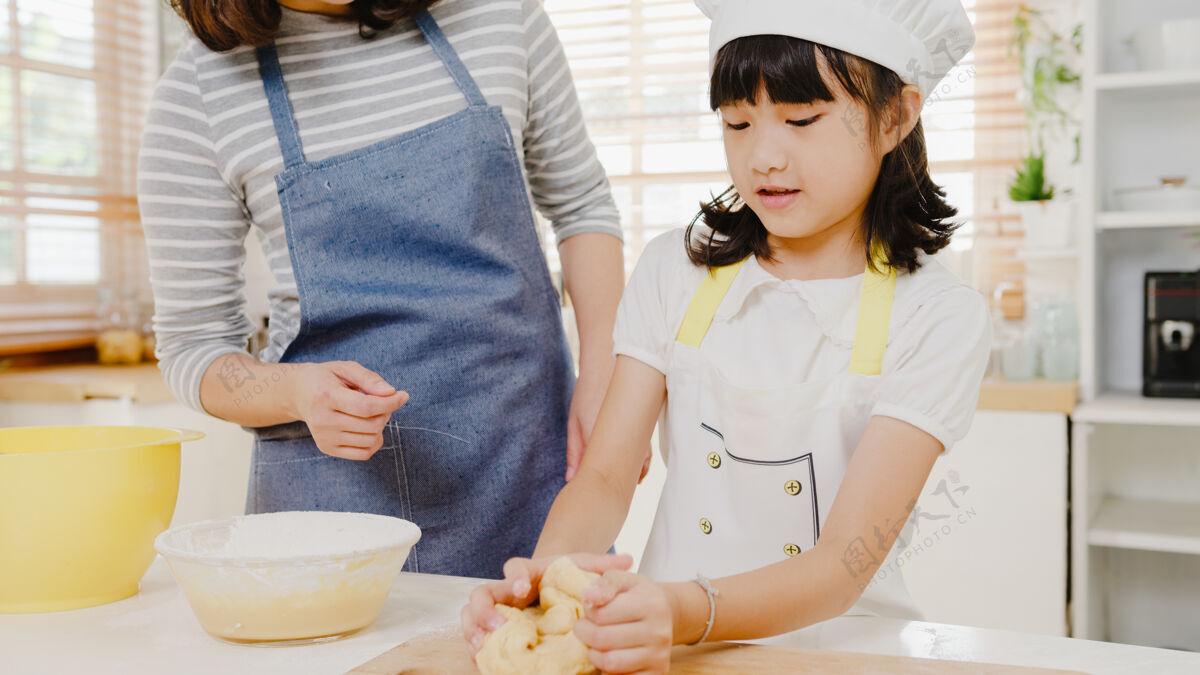 制作快乐微笑的日本亚裔小家庭 带着学龄前的孩子 享受烹饪烘焙糕点的乐趣厨房揉捏父母