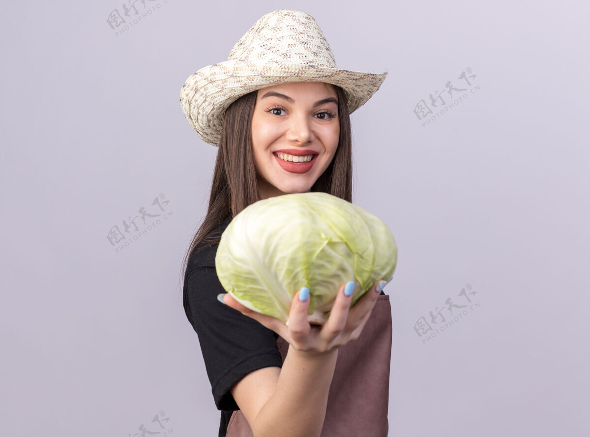 漂亮笑容可掬的白人女园丁戴着园艺帽站在一旁捧着卷心菜立场卷心菜穿
