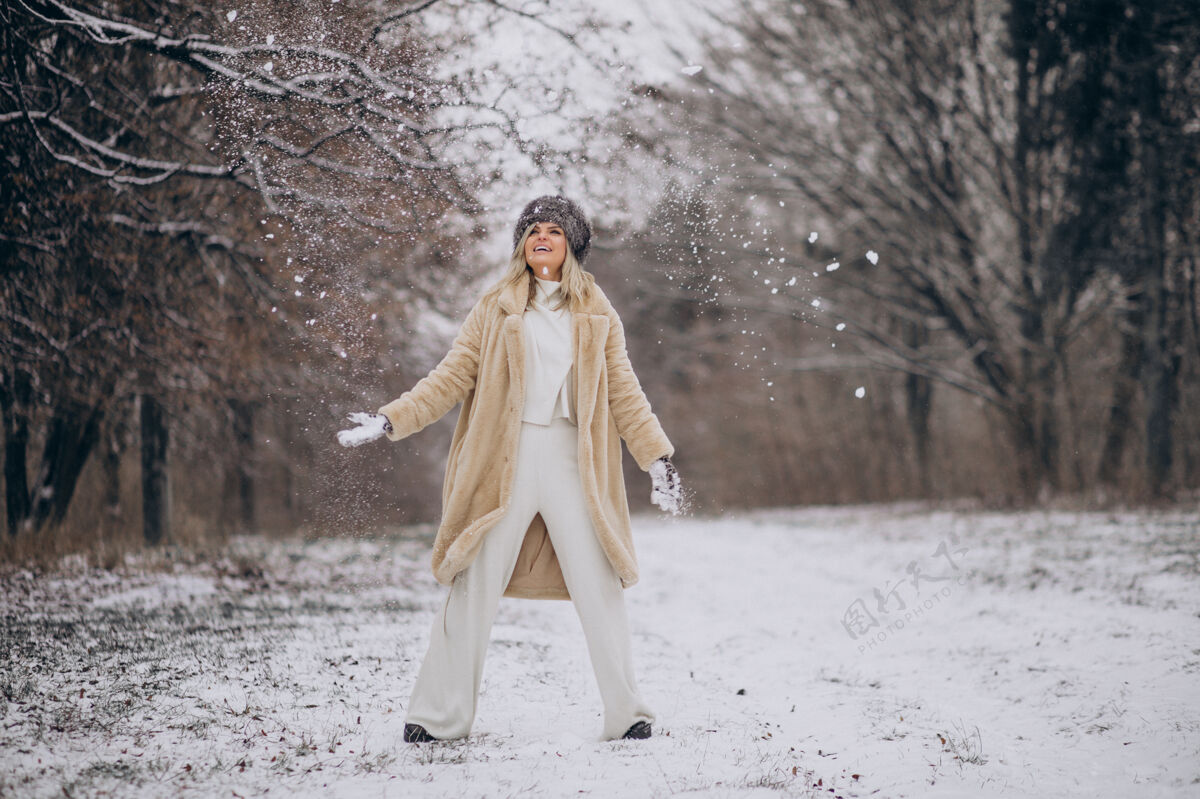 女性美丽的女人在满是雪的公园里散步温暖的衣服冒险女孩