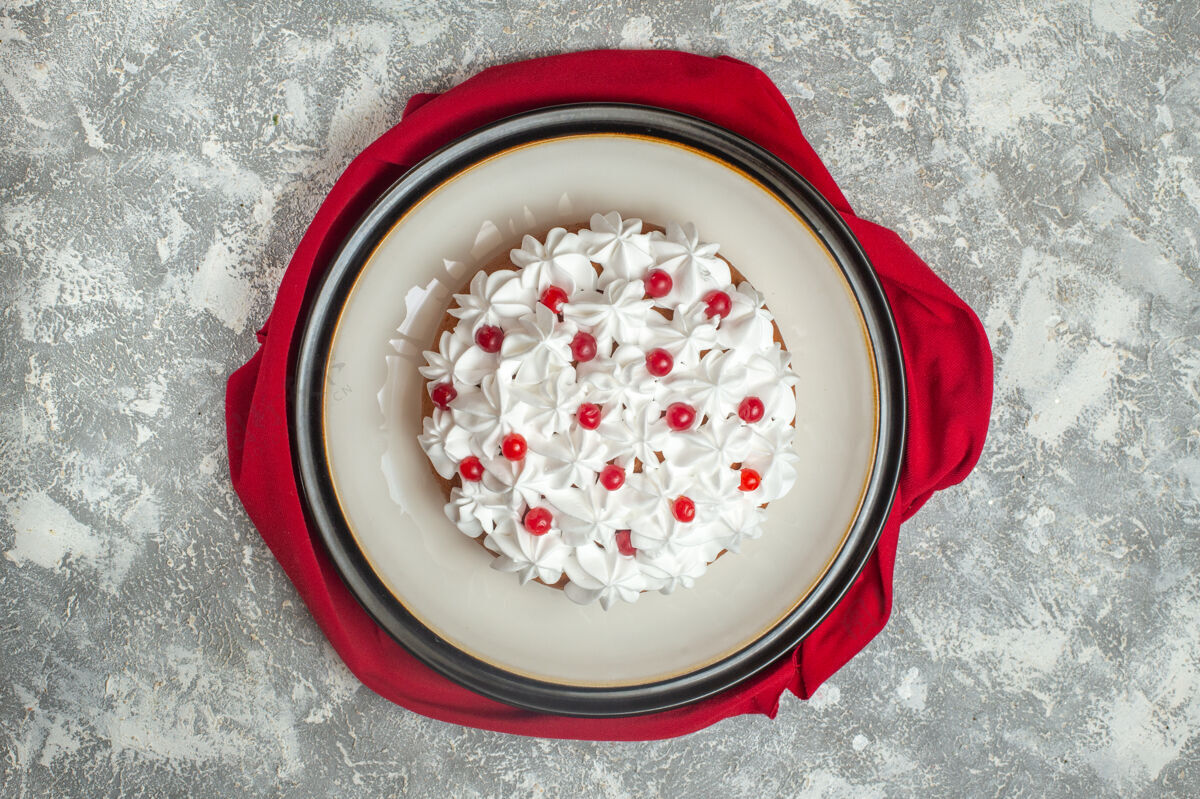 美味美味奶油蛋糕的俯视图 在冰背景上的红色毛巾上装饰着水果冰健康新鲜