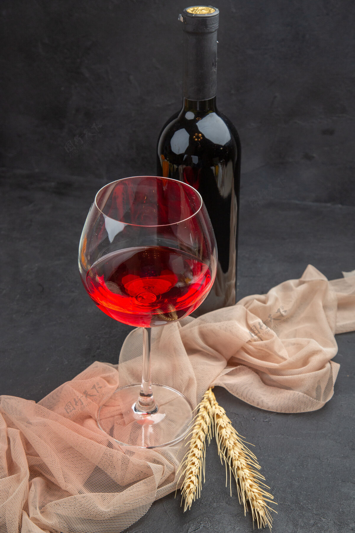 葡萄酒正面近距离观看红酒在毛巾上的玻璃高脚杯和黑色背景上的瓶子庆典酒杯酒杯