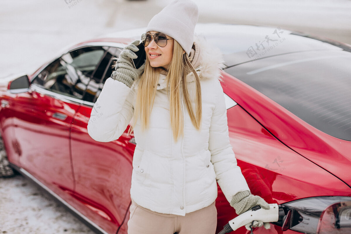充电女人充电红色电动车 在冬天的时候成功汽车电话
