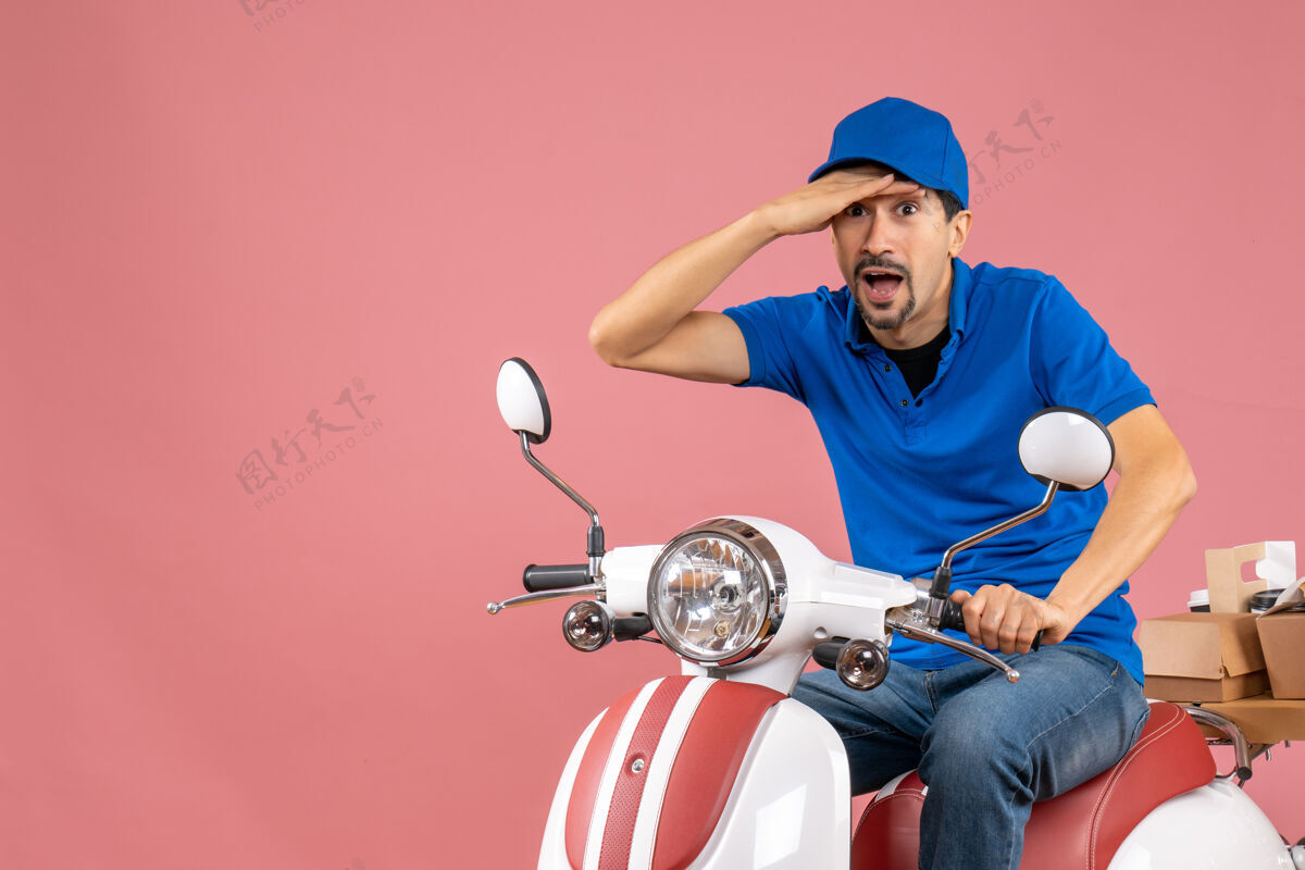 运动俯视图惊讶的快递员戴着帽子坐在滑板车上传递粉彩桃订单人车辆人