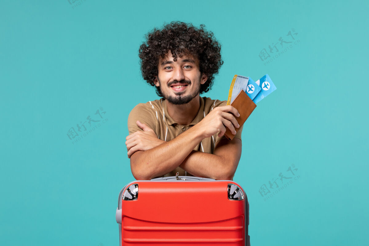 视图度假的人拿着票 靠在蓝色的红袋子上旅程旅行肖像