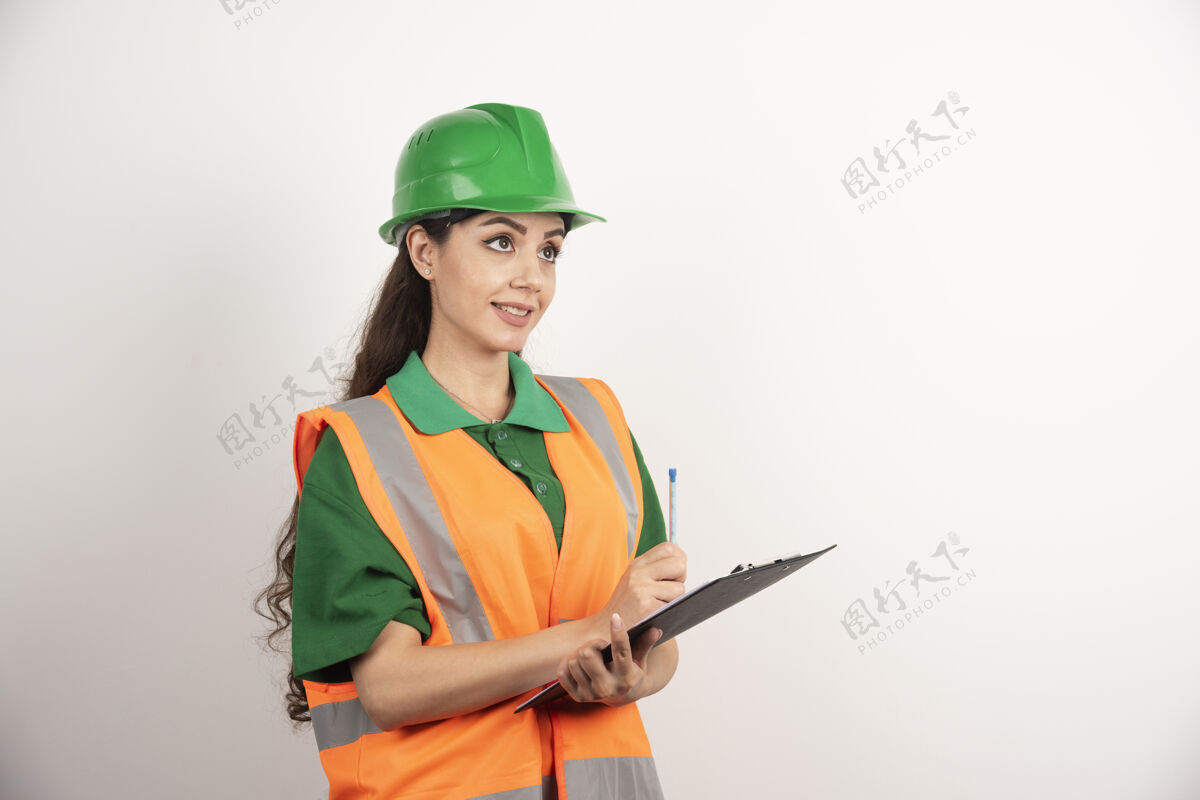 安全帽微笑的女工程师与剪贴板上的白色背景高品质的照片女孩头盔女士