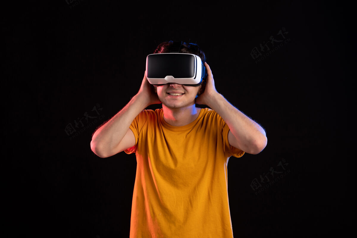 游戏在黑暗的墙上戴着虚拟现实耳机的年轻人的正视图男人人视频