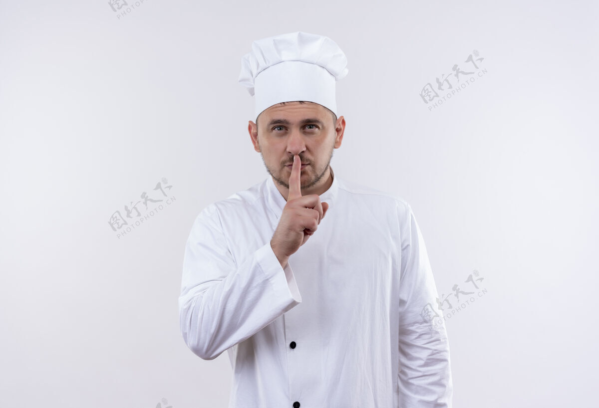 自信自信的年轻帅哥厨师身着厨师制服 在白色的墙壁上用复制空间表示沉默年轻制服姿态