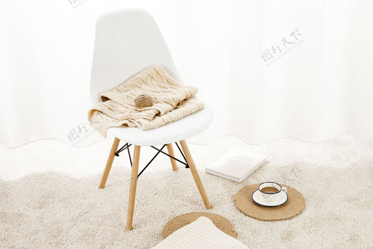 家具一张椅子的特写 上面有毛毯 毛绒绒的地毯上有一杯咖啡和一个记事本记事本地板室内