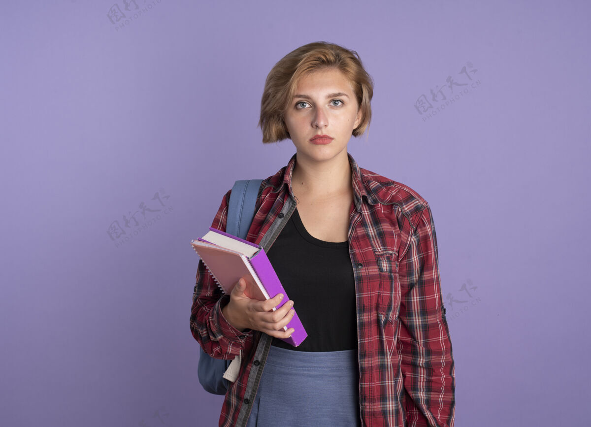 笔记本自信的年轻斯拉夫女学生背着书包拿着书和笔记本斯拉夫紫色空间