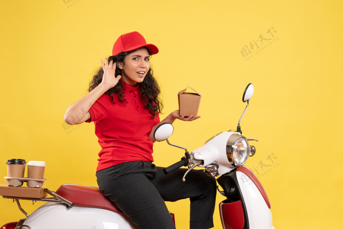制服前视图女快递员骑自行车送咖啡和食物 背景是黄色的服务工作服 工作服 工作女工送货自行车女快递