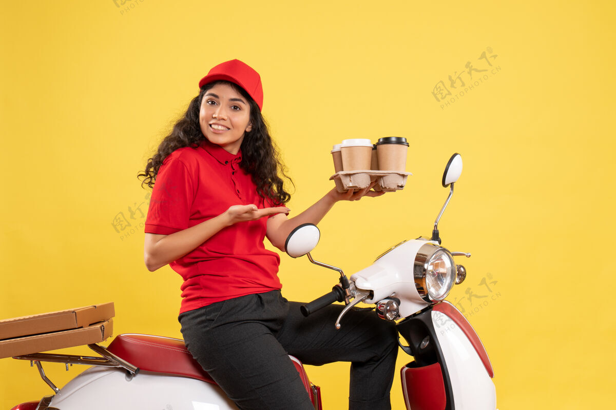 女信使前视图骑自行车的女快递员拿着咖啡杯在黄色背景上工作服工作服女快递员工作工作送货制服