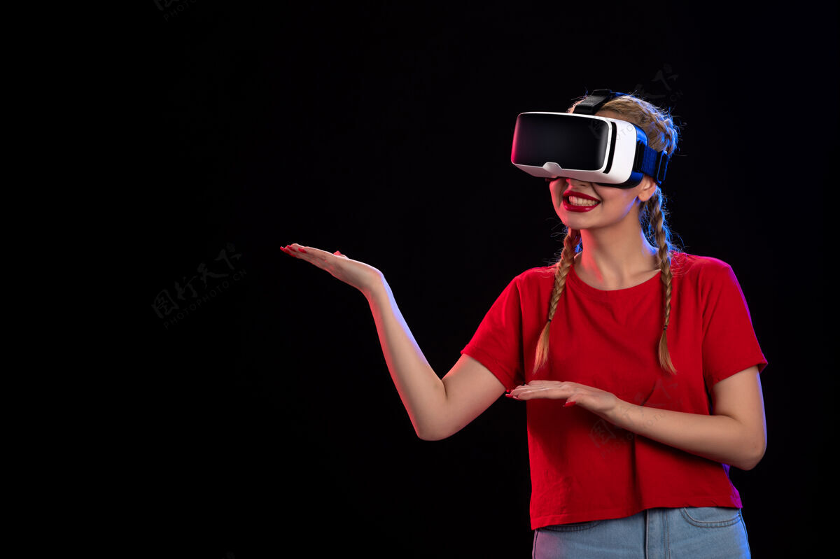 姿势年轻女性在黑暗的墙上玩虚拟现实的正面图虚拟现实肖像人物