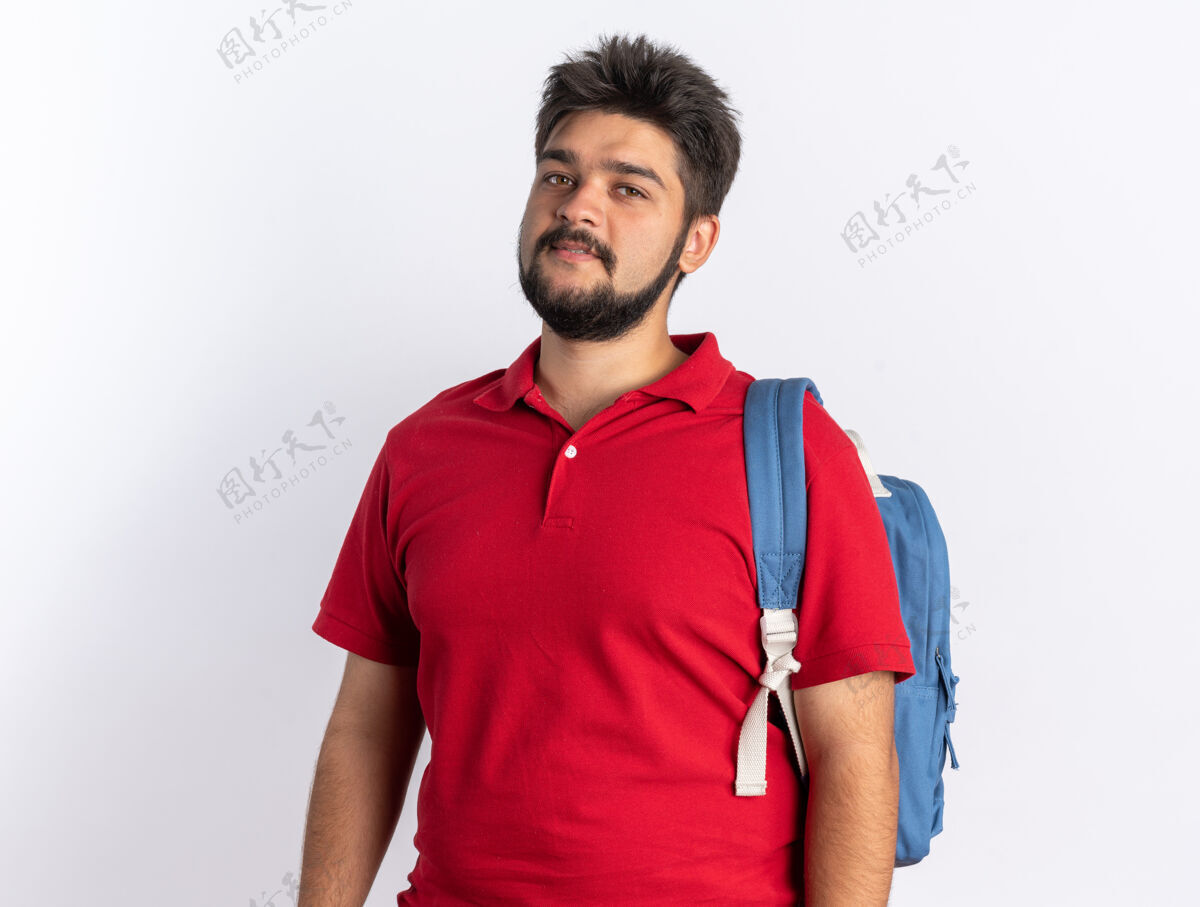 胡须年轻的留着胡子的学生 穿着红色马球衫 背着背包 站在那里微笑自信背包年轻微笑