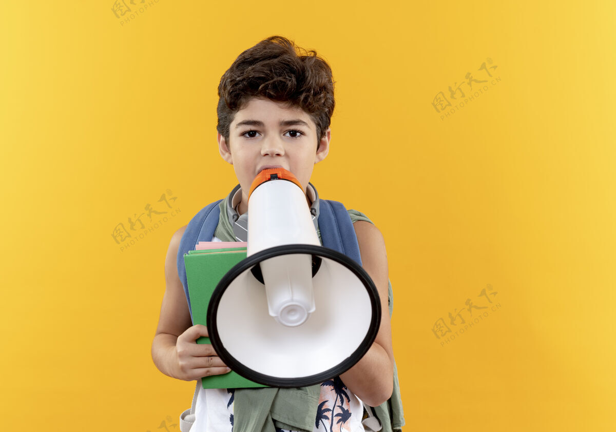 说话看着那个背着书包戴着耳机拿着书用扩音器说话的小男孩包抱男孩