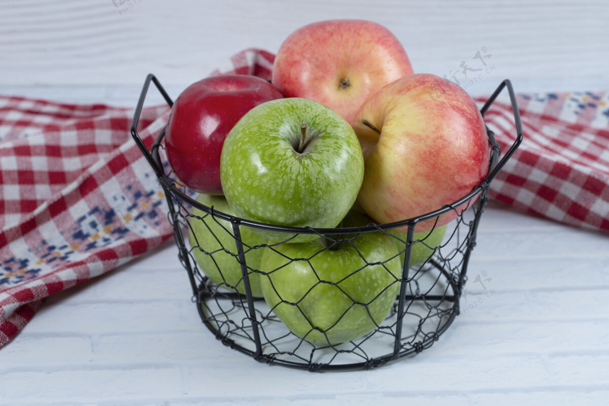 成熟红色和绿色的苹果放在金属黑色的篮子里 放在白色的背景上高质量的照片食物有机健康