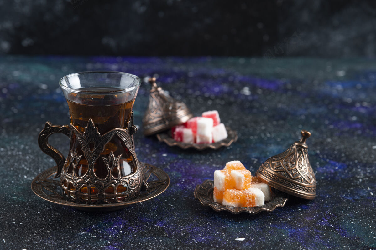 茶壶热茶和果酱在蓝色表面的特写照片特写茶金属