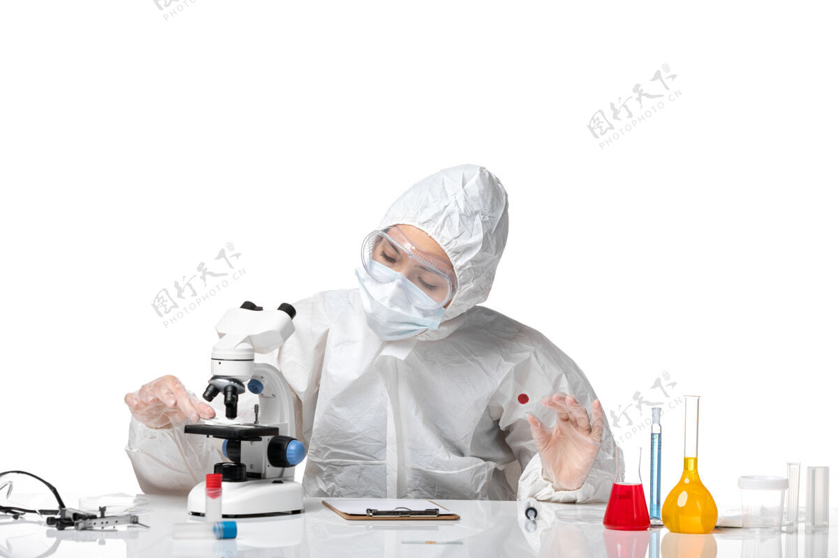 病毒正面图年轻的女医生穿着白色防护服 戴着口罩 由于科维德工作在一个浅白色的背景大流行病毒健康科维德-工作医生面罩