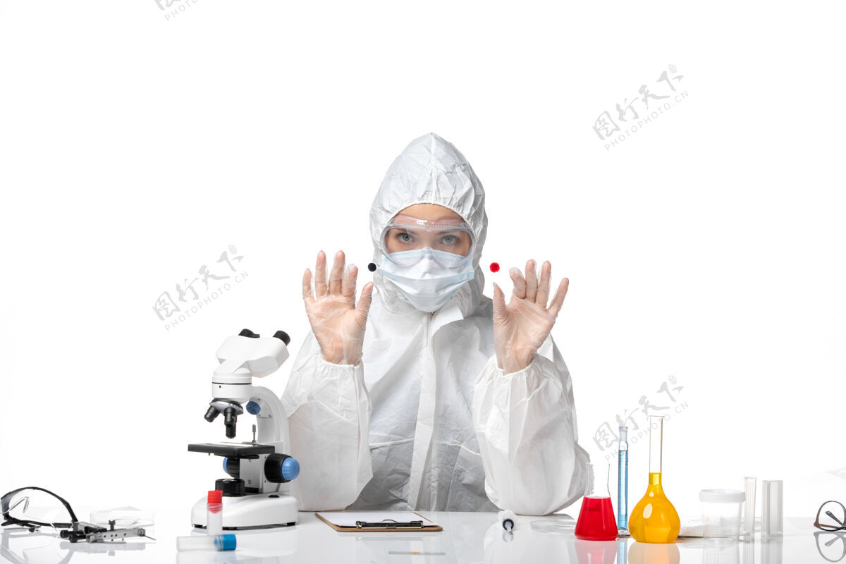 制服正面图年轻女医生穿着白色防护服 戴着口罩 由于科维德工作在白色背景下大流行病毒健康科维德-套装医疗医生