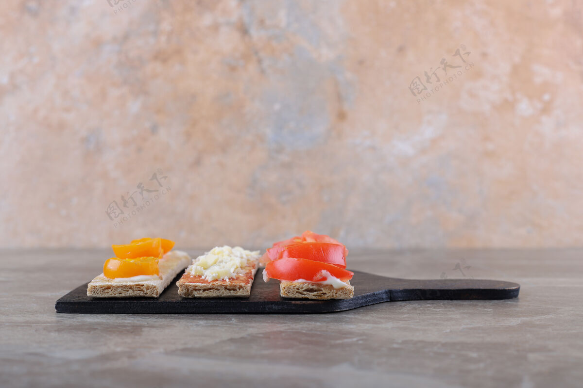 风味把熟的和未熟的西红柿切成薄片 放在切菜板上的酥皮面包上 放在大理石表面美味面筋配料