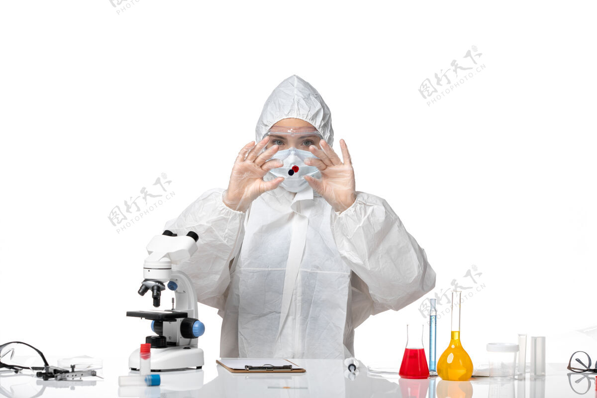 药正面图年轻女医生穿着白色防护服 戴着口罩 因为科维德工作在白色背景大流行病毒健康科维德病毒医生成人