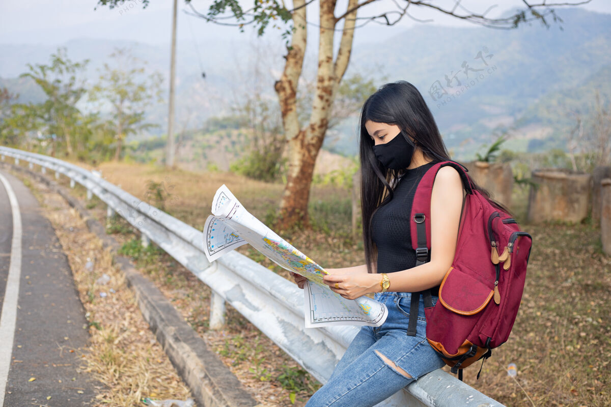 旅游旅游女孩在地图上寻找正确的方向外科口罩背包亚洲