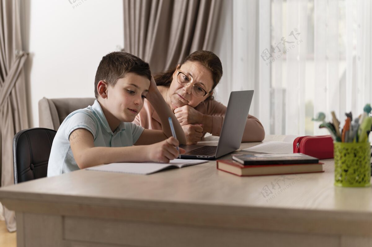 女性小男孩和奶奶在笔记本电脑上做作业室内祖母女士