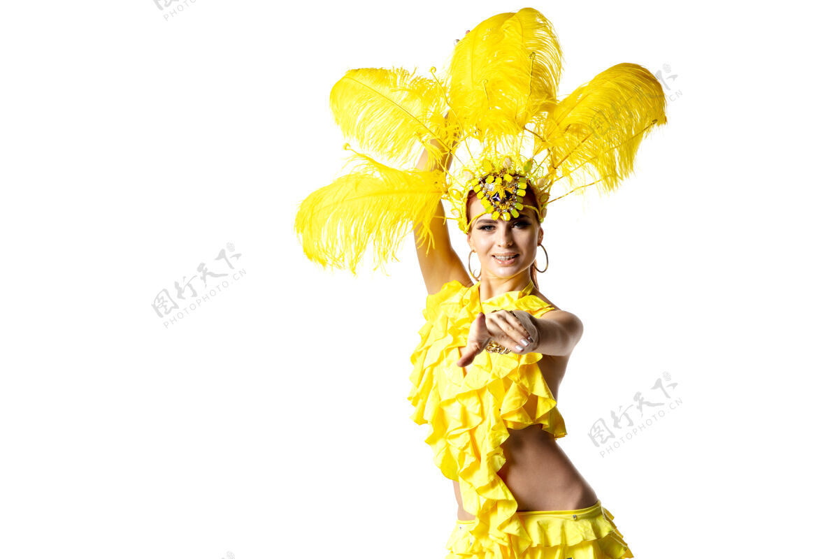 新表演身着嘉年华化装 黄色羽毛的美丽年轻女子在白色背景上翩翩起舞节日庆典 节日时间 舞蹈 聚会 快乐的概念复制空间女性神秘戏剧