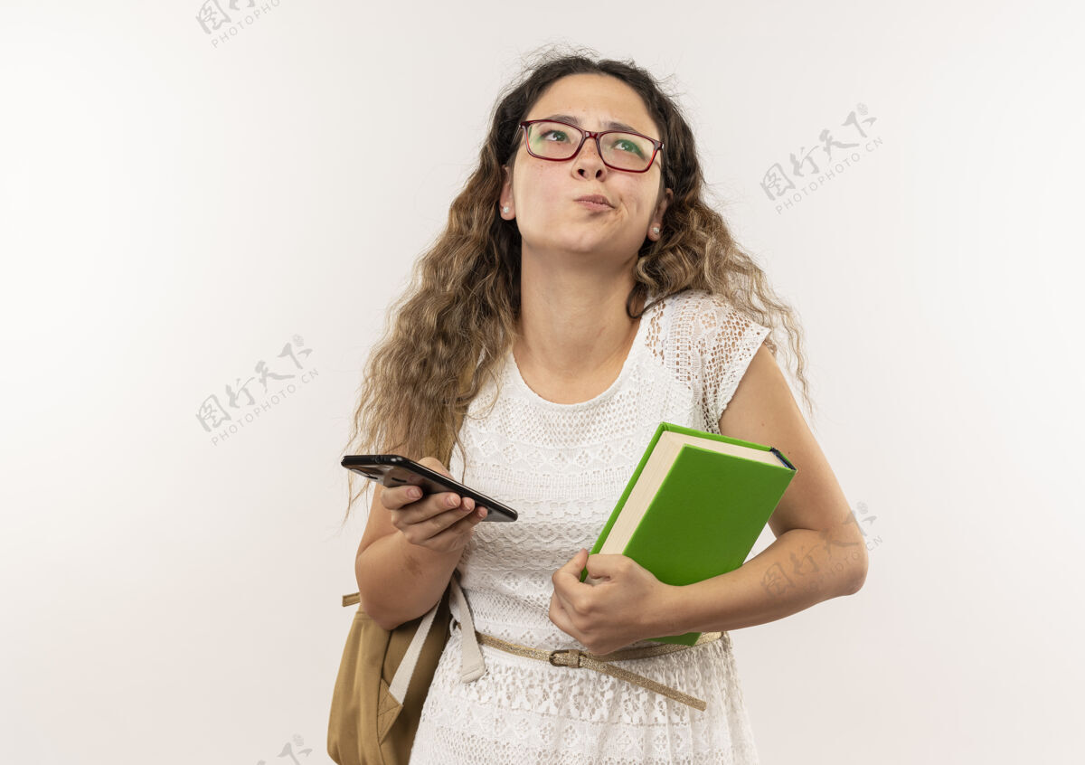 市民体贴的年轻漂亮女生戴着眼镜 背着书包 拿着手机 孤零零地看着白色的墙上穿白衣服