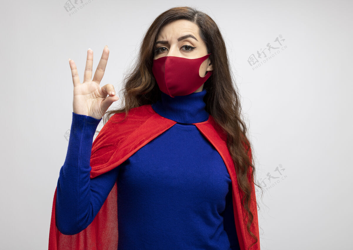 超级英雄自信的高加索超级英雄女孩 穿着红色斗篷 戴着红色防护面具信心斗篷手