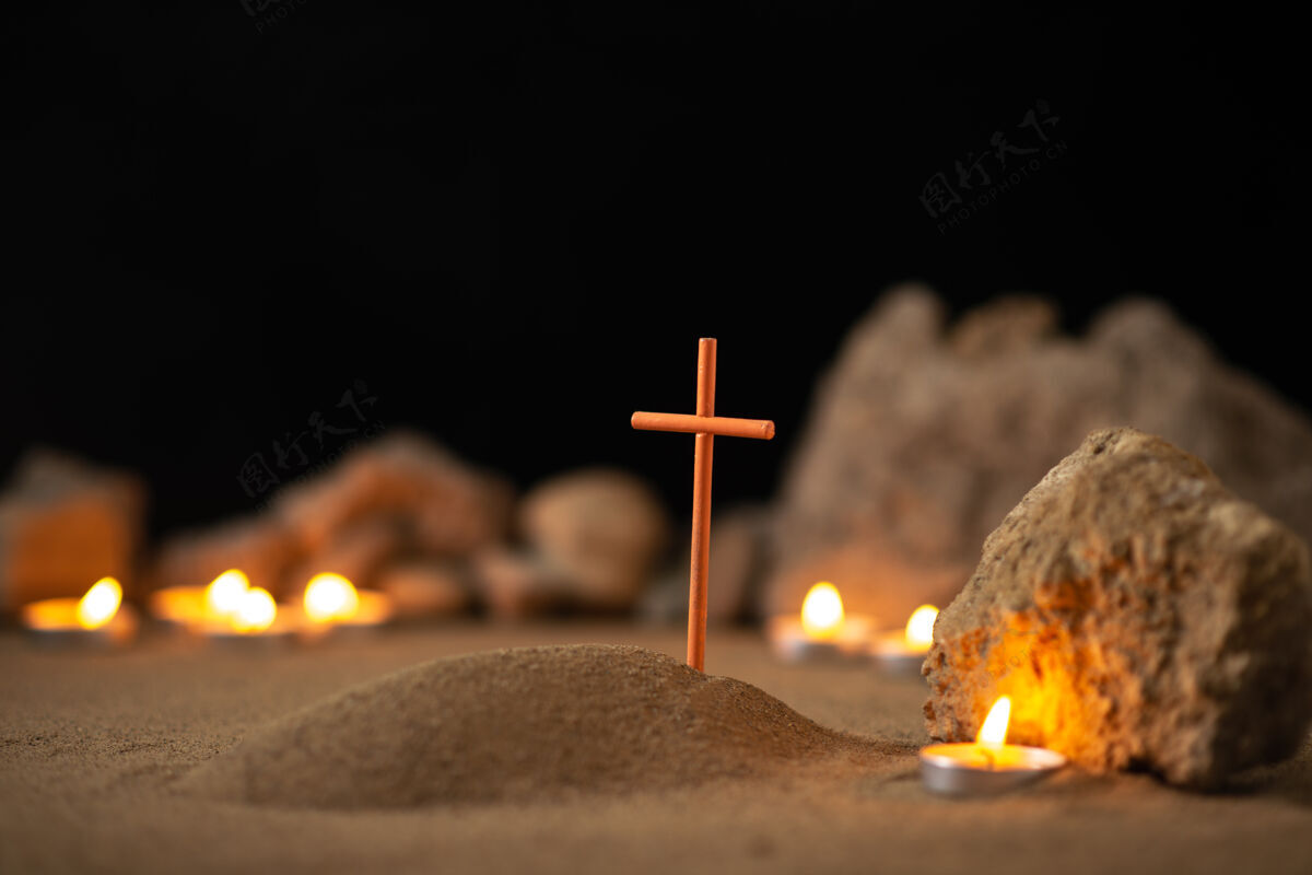 热在黑暗的表面上有石头和蜡烛的小坟墓燃烧蜡烛石头