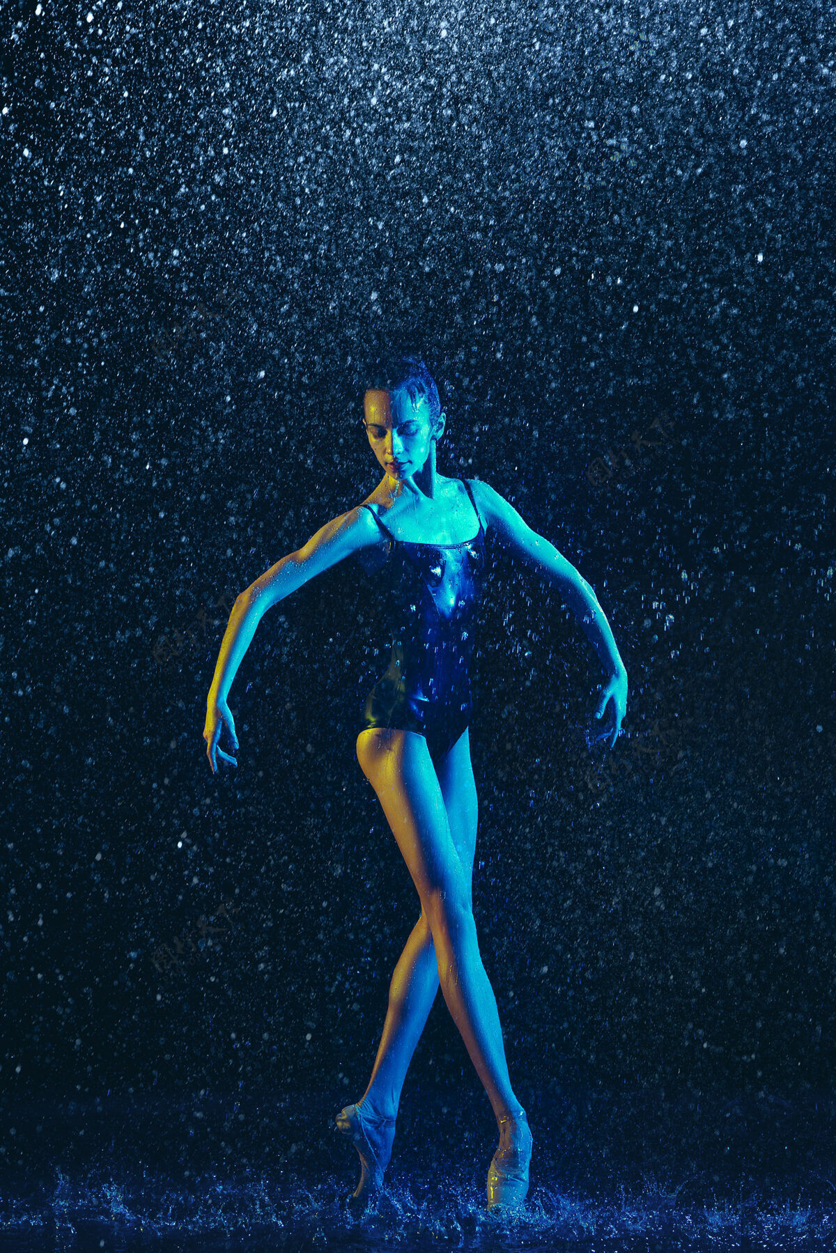 平衡两个年轻的女芭蕾舞演员在水滴下表演体操舞蹈