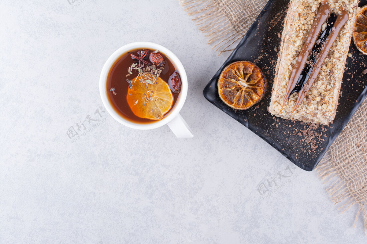 粗麻布一盘自制蛋糕和水果茶放在大理石表面自制面包房茶
