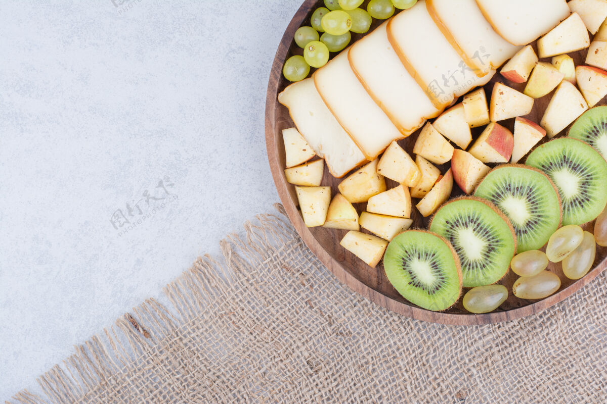 苹果一个装满切片水果和面包的木盘面包水果猕猴桃