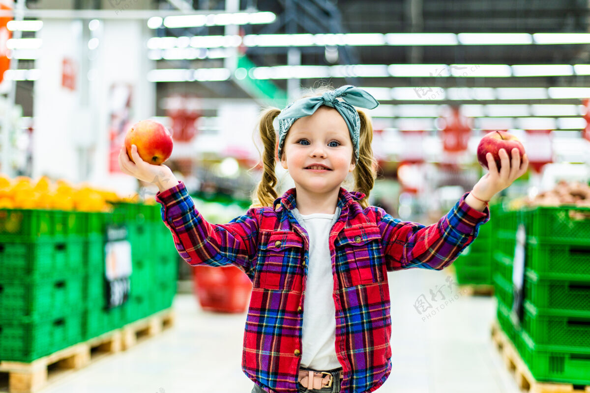 快乐小女孩在食品店或超市挑选苹果苹果女孩杂货店