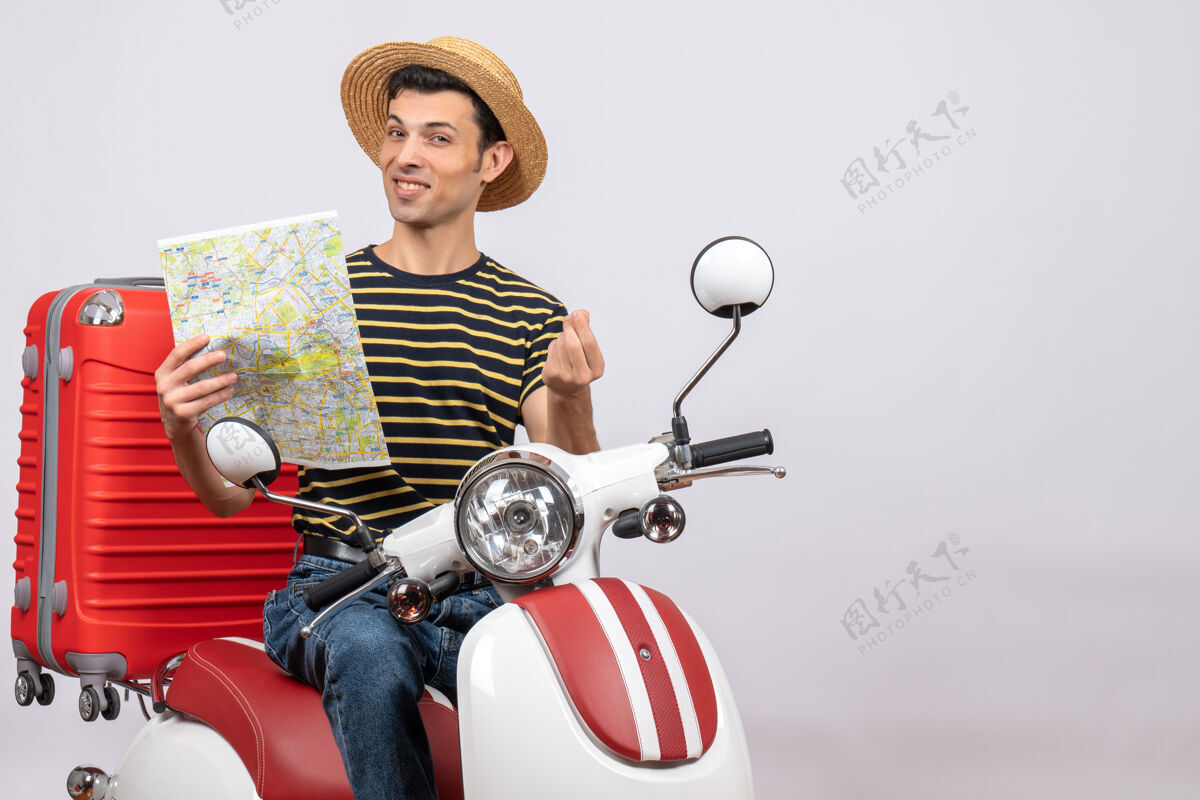 摩托车手持轻便摩托车的地图上戴着草帽的幸福青年的正视图帽子骑车辆