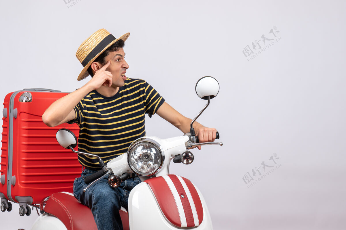 年轻人一个戴着草帽的年轻人坐在轻便摩托车上看右前方摩托车人视图
