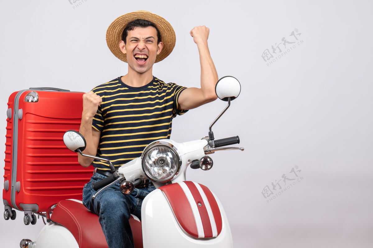 车辆骑着轻便摩托车戴着草帽的年轻人表达幸福的正面图前面稻草微笑