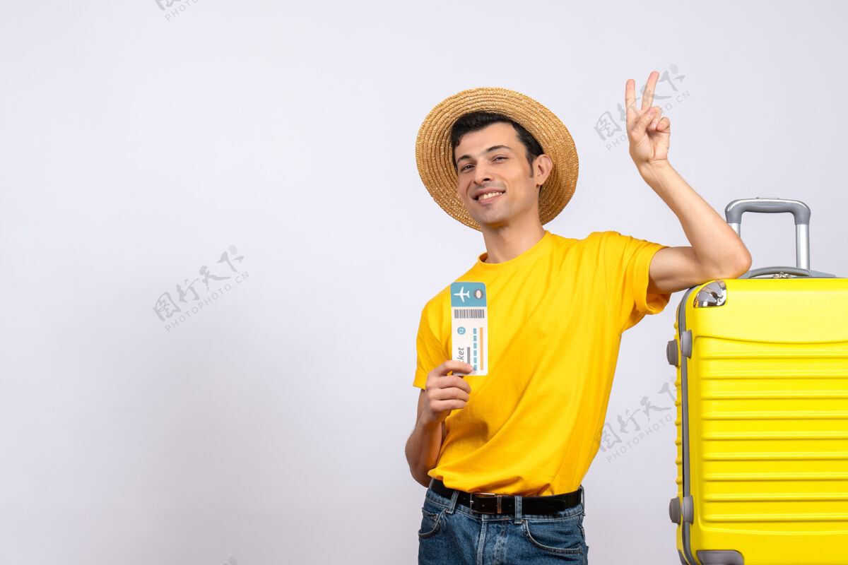 年轻人正面图穿着黄色t恤的年轻人站在黄色手提箱旁 手里拿着制票v牌风景男T恤