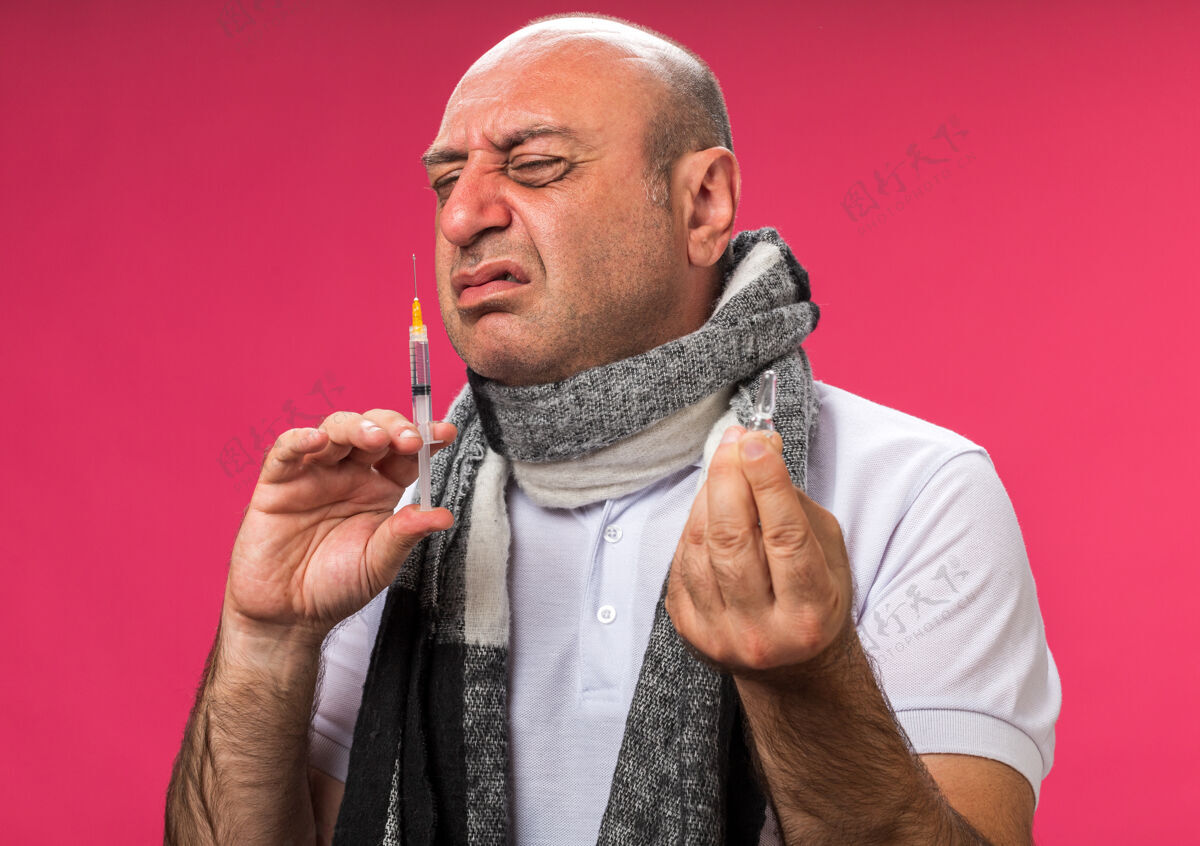 手持未经许可的成年白种人患病 脖子上围着围巾 拿着安瓿和嗅注射器 隔离在粉色墙上 留有复印空间白种人注射器周围