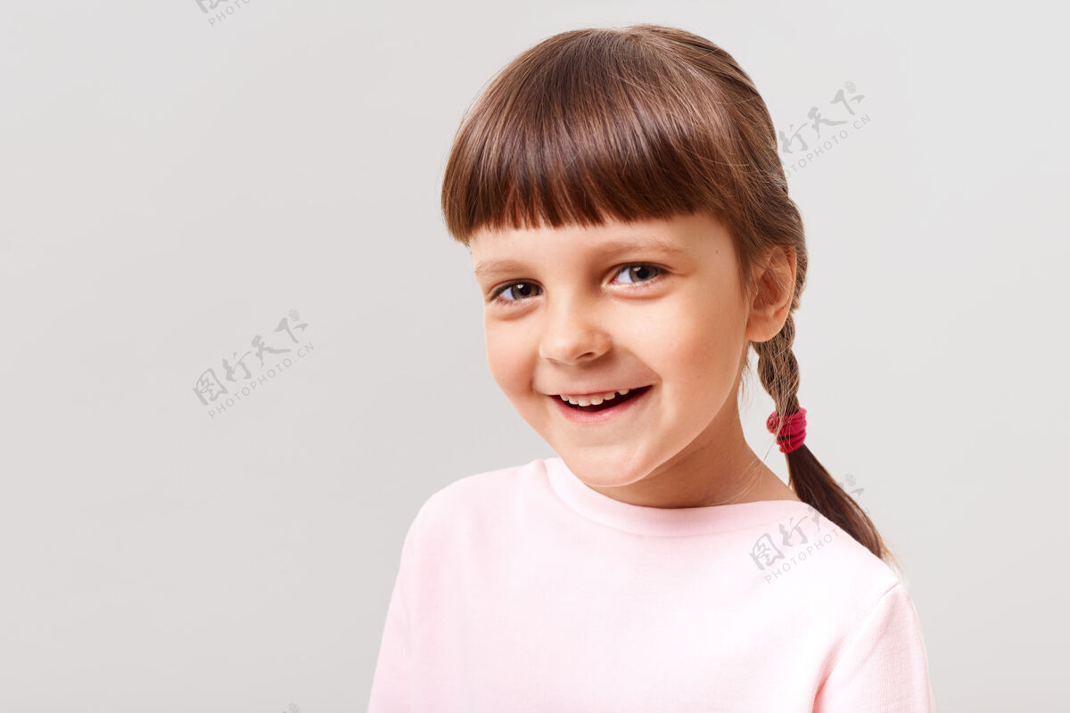 孩子迷人的微笑着穿着粉色毛衣的女孩儿带着幸福的表情看着前面青春期亲吻欢笑