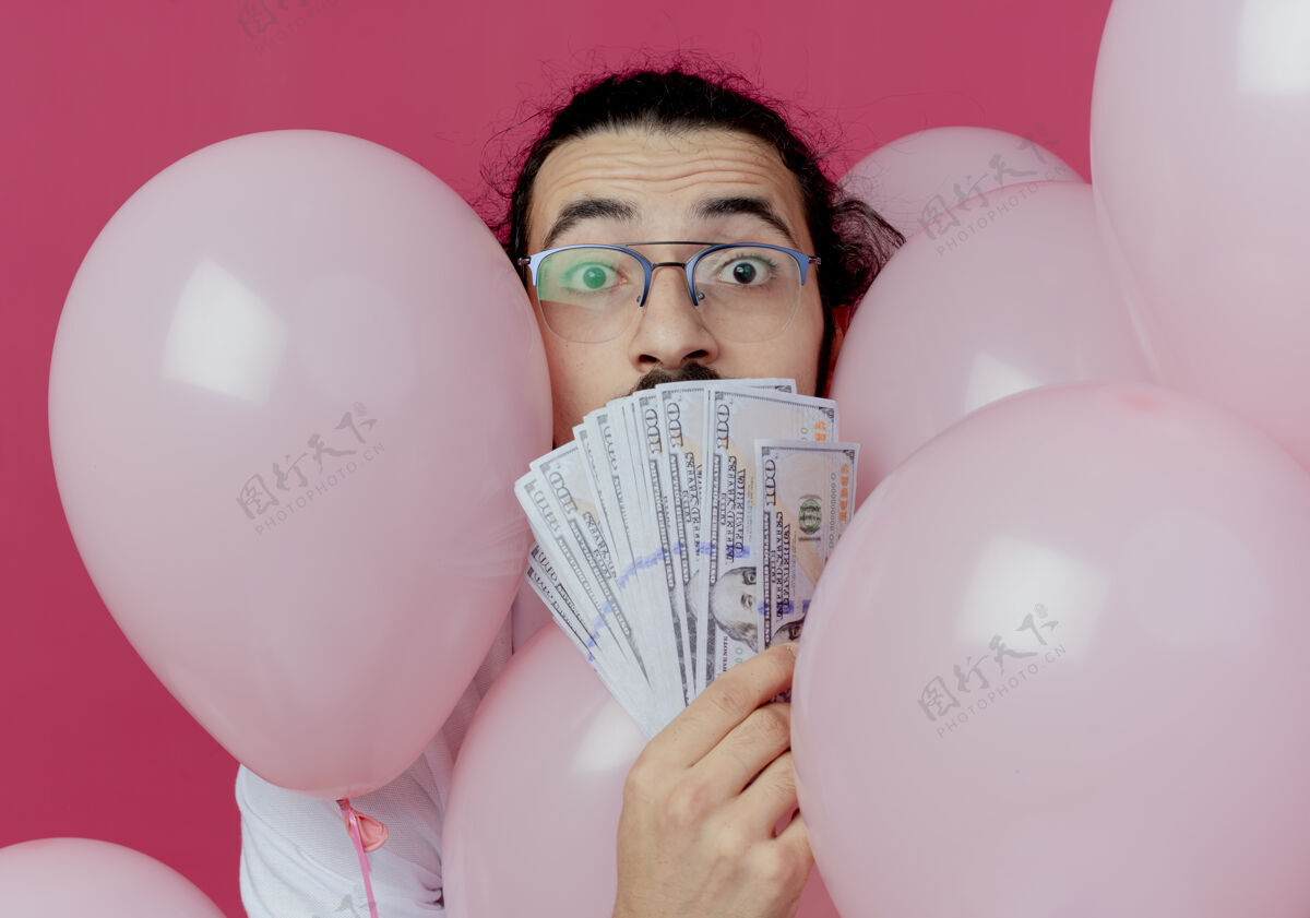 背景一个戴眼镜的帅哥站在气球中间 嘴里塞满了现金封面惊喜帅哥