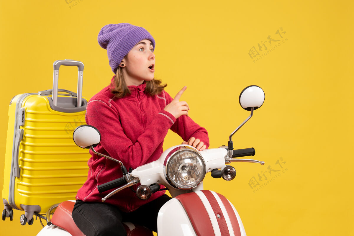 车辆前视图坐在轻便摩托车上的年轻女子盯着我看成人轻便摩托车前面