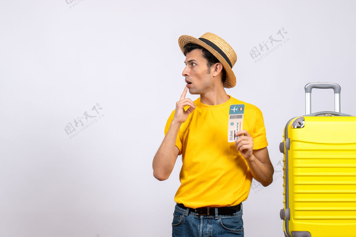 T恤正面图一个穿着黄色t恤的年轻人站在黄色手提箱旁看着什么成人前面视图