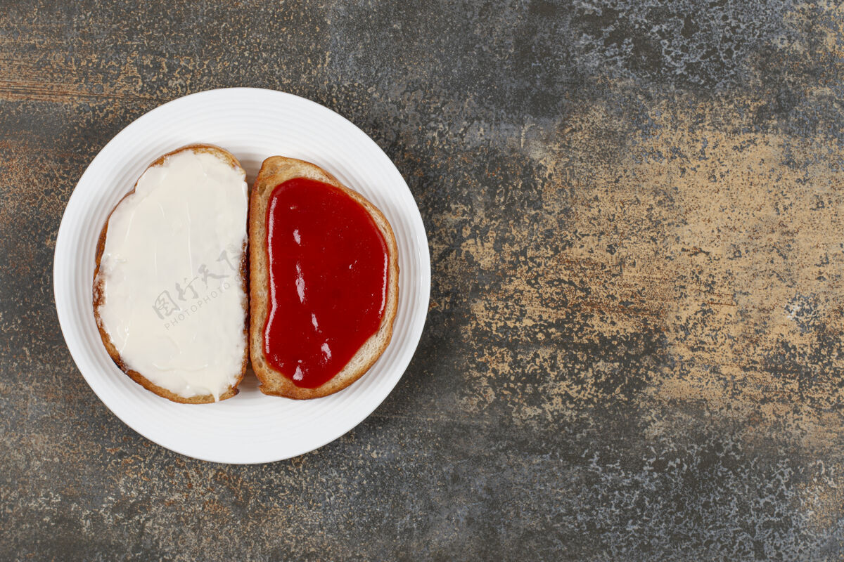 面包在白色盘子上烤草莓酱和酸奶油早餐小吃三明治