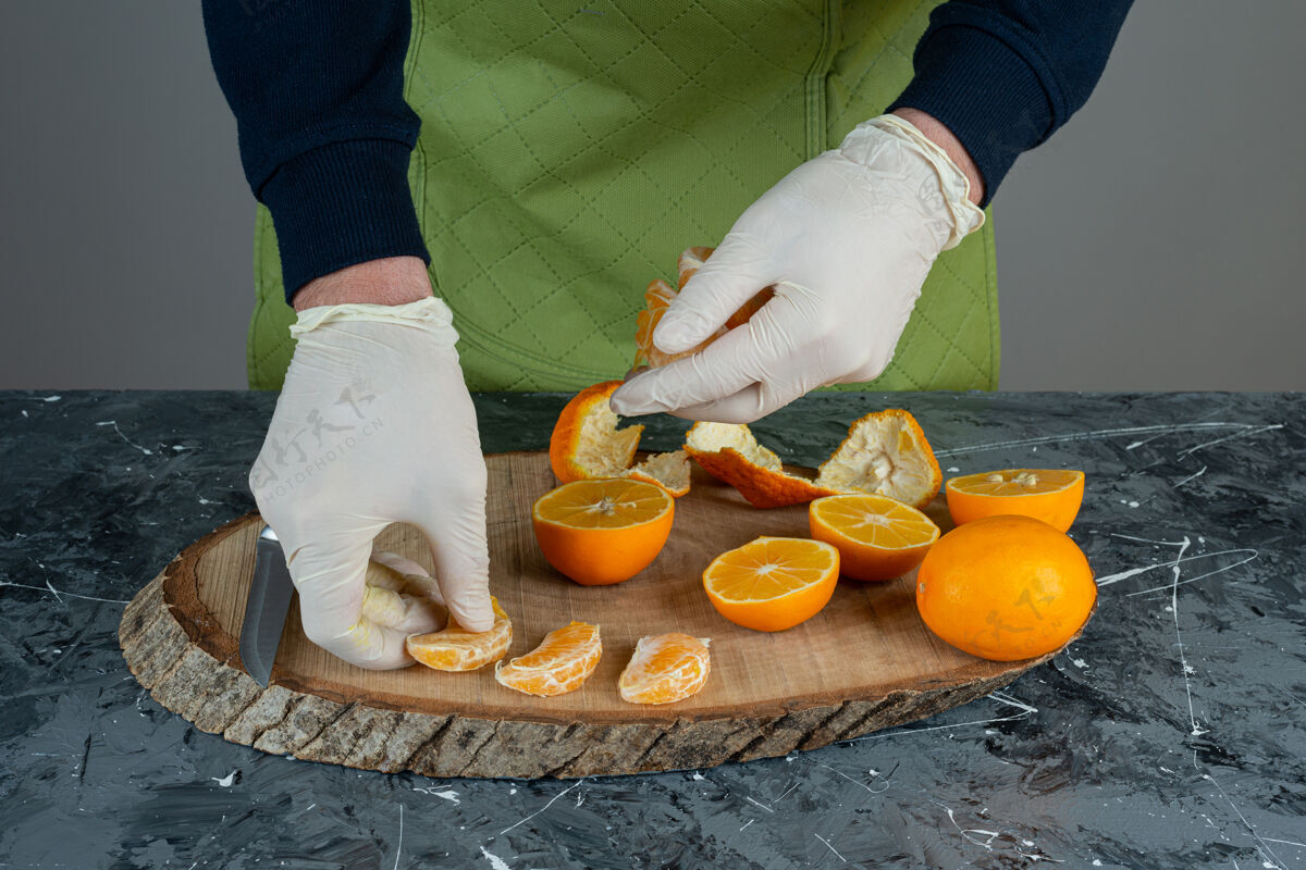 各种男性手戴手套 手拿橘子片放在大理石桌上男水果橘子