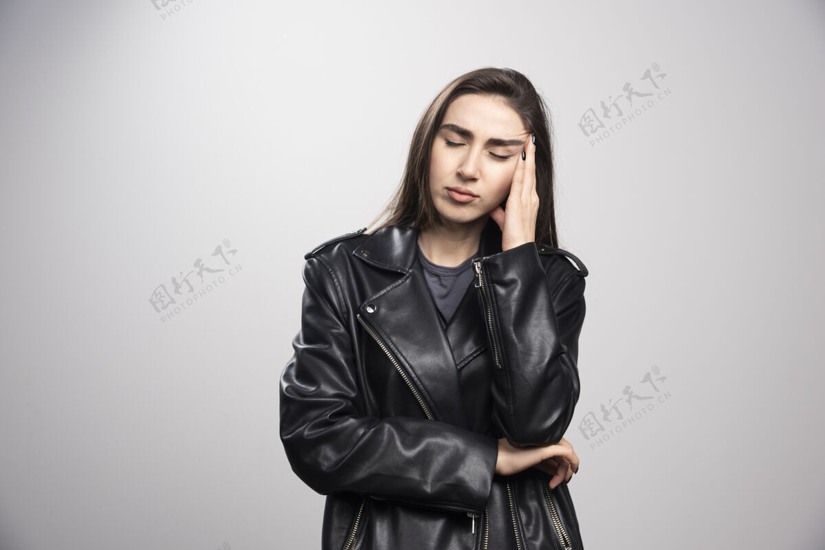 女性一位穿着黑色皮夹克的美女抚摸头发的照片模特黑色夹克皮夹克