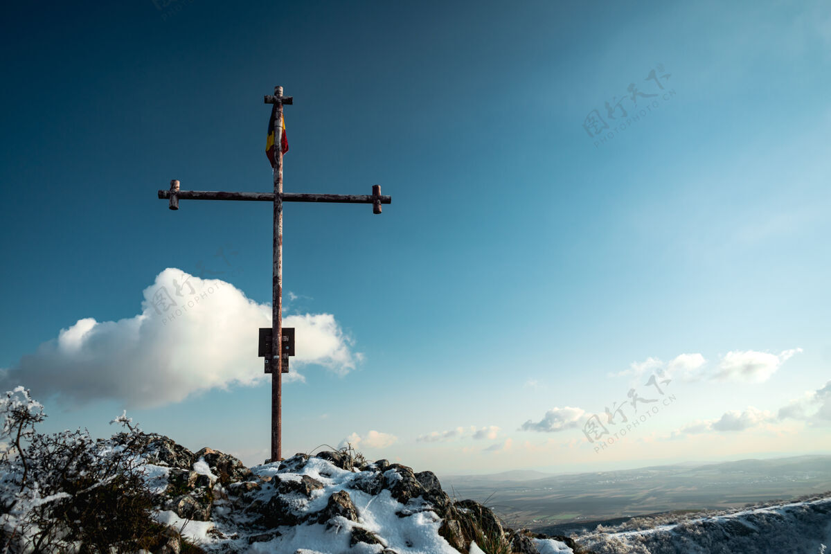 旅行基督金属十字架站在岩石上与国旗十字架岩石地标