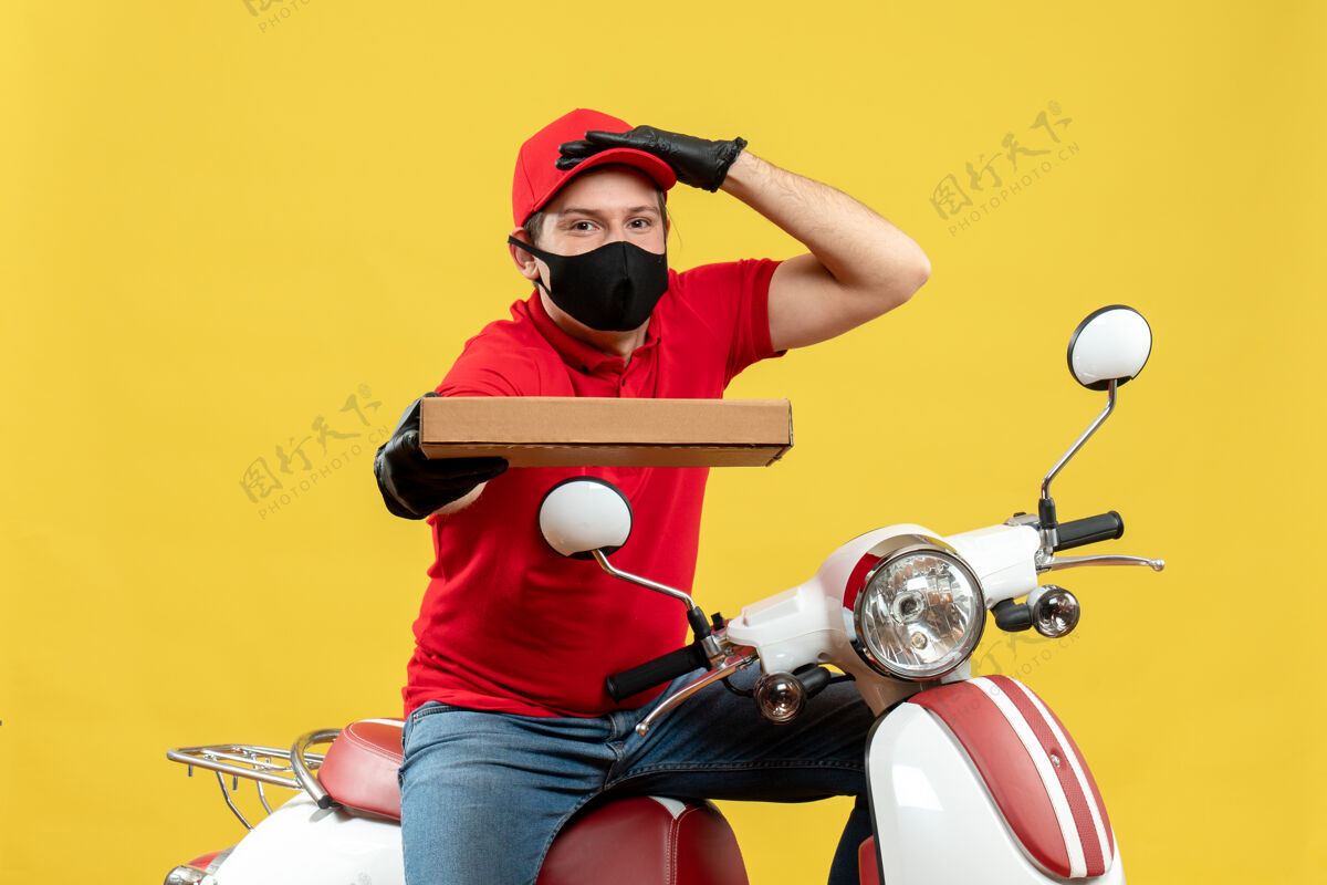男子俯视图集中快递员身穿红色上衣 戴着帽子手套 戴着医用面罩坐在滑板车上显示秩序摩托车车辆运动