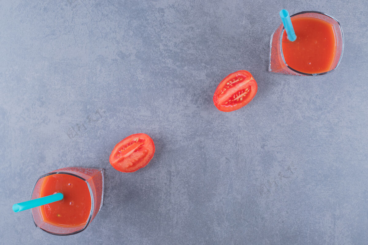 番茄一杯新鲜番茄汁和番茄的顶视图 背景为灰色健康板美味